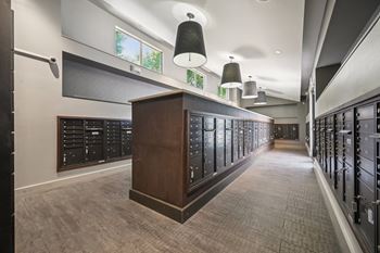 A long hallway with a row of lockers on the right and a wooden cabinet in the middle at Everra Midtown Park Apartments, Dallas
